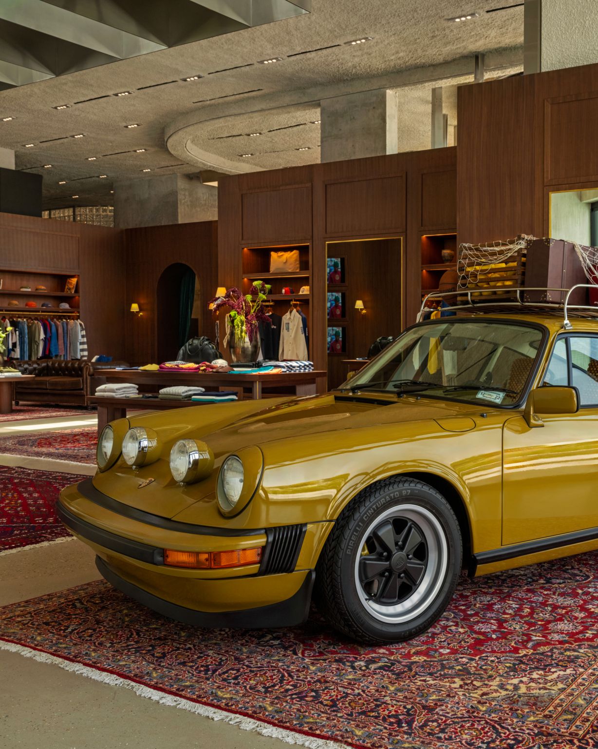 A mustard-gold Porsche displayed inside the Aimé Leon Dore x Ounass Dubai environment