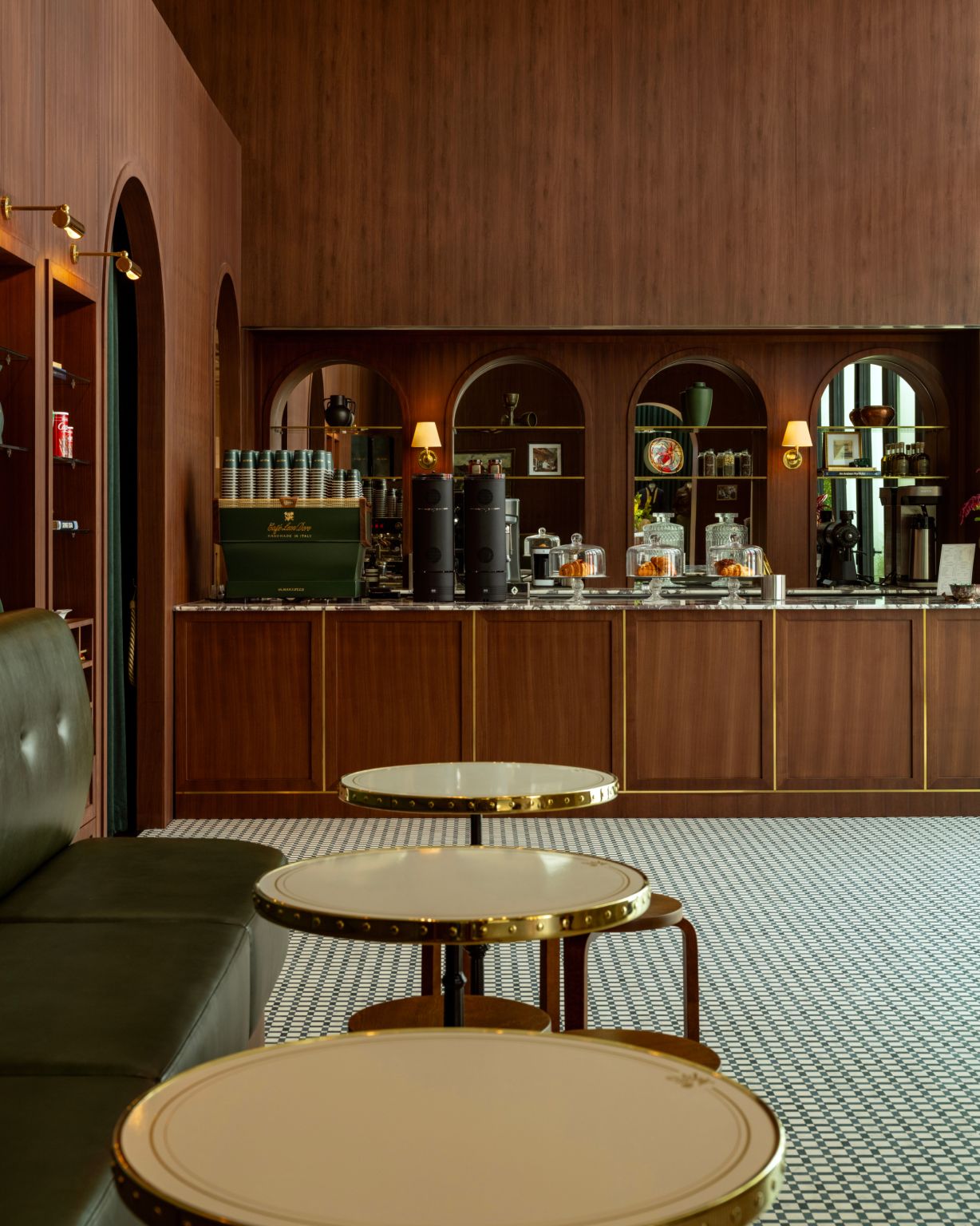 Cafe area with dark walnut joinery, brass details and patterned floor tiles