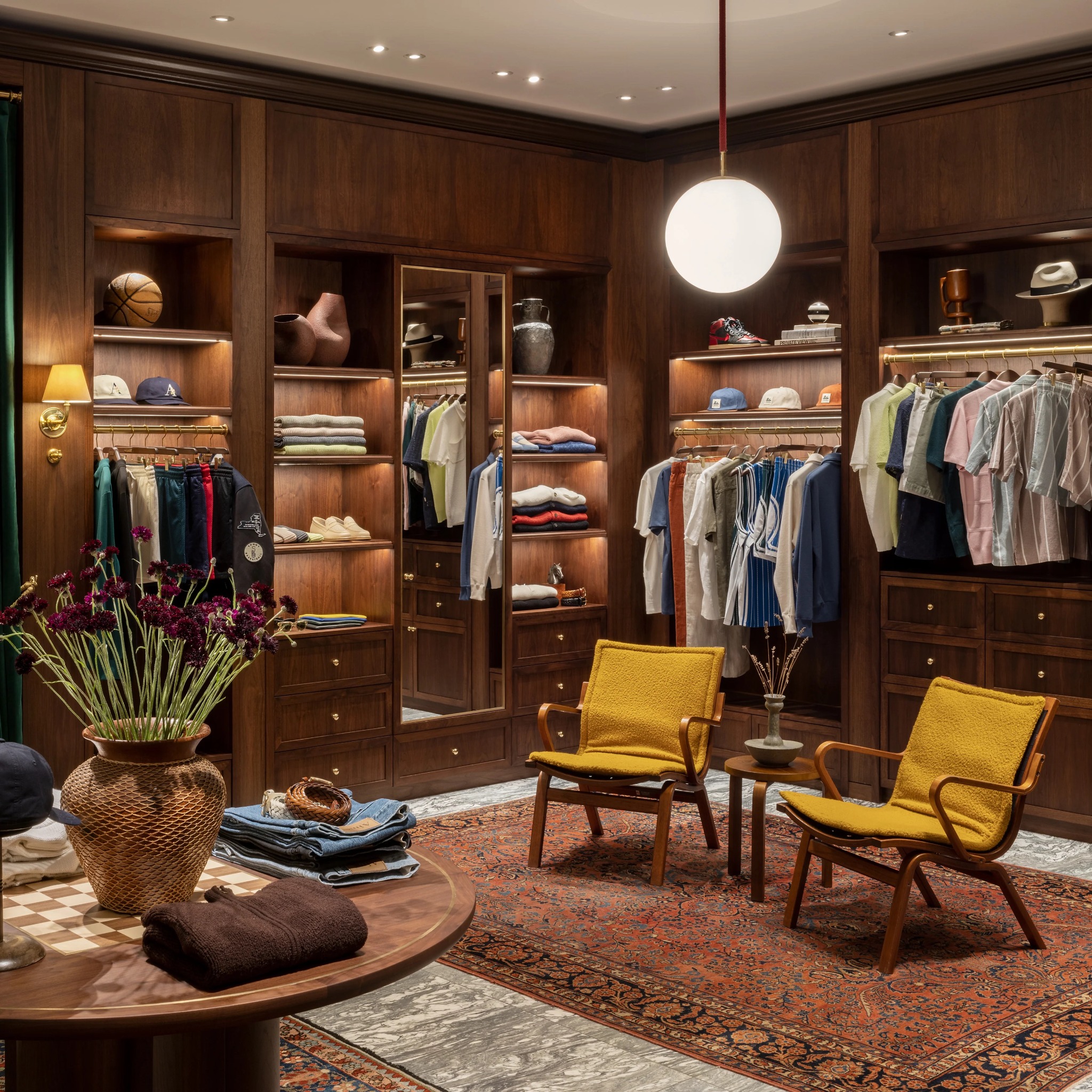 Merchandised apparel bays with lounge chairs and sculptural floral display