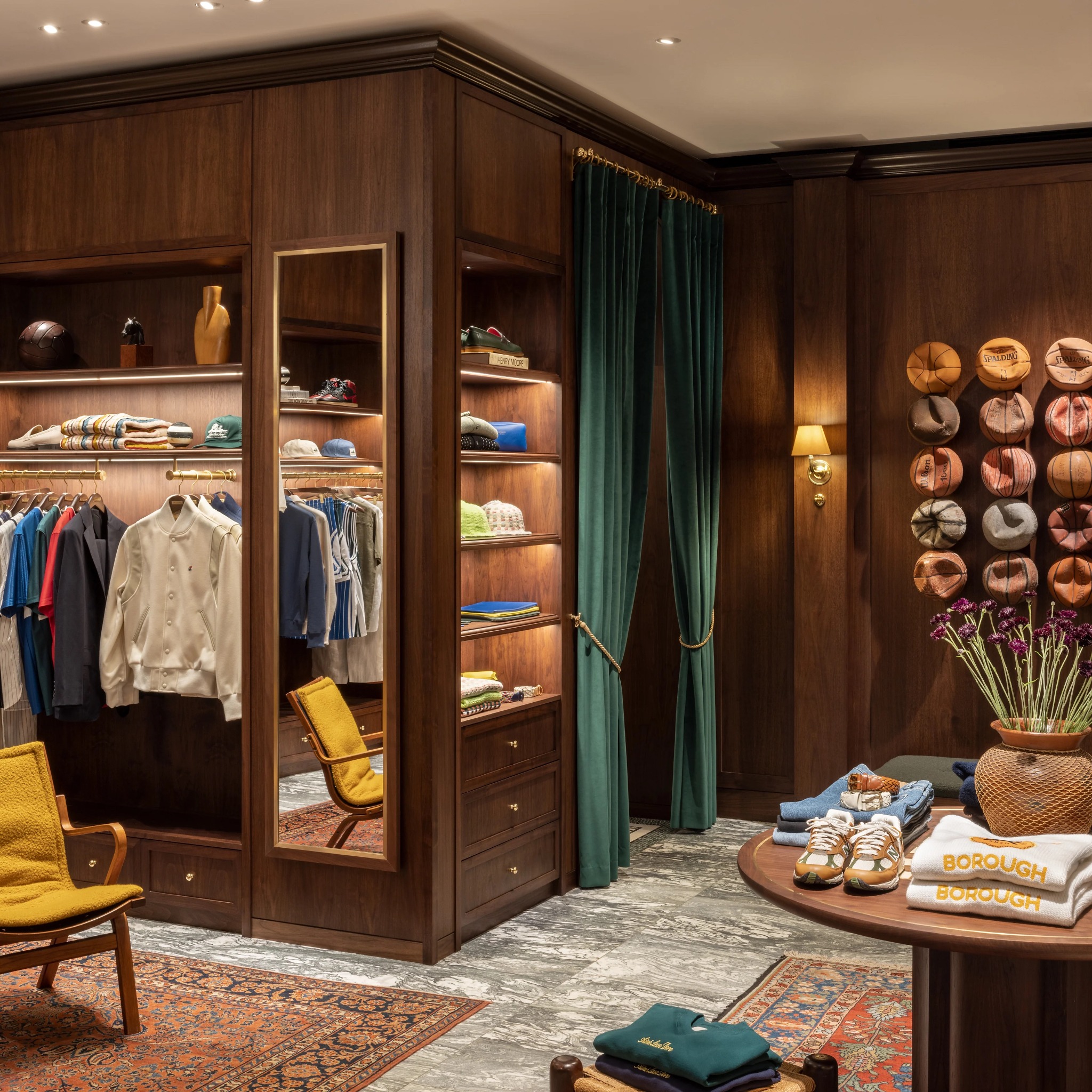 Close view of apparel fixtures, green velvet curtains and a styled product table